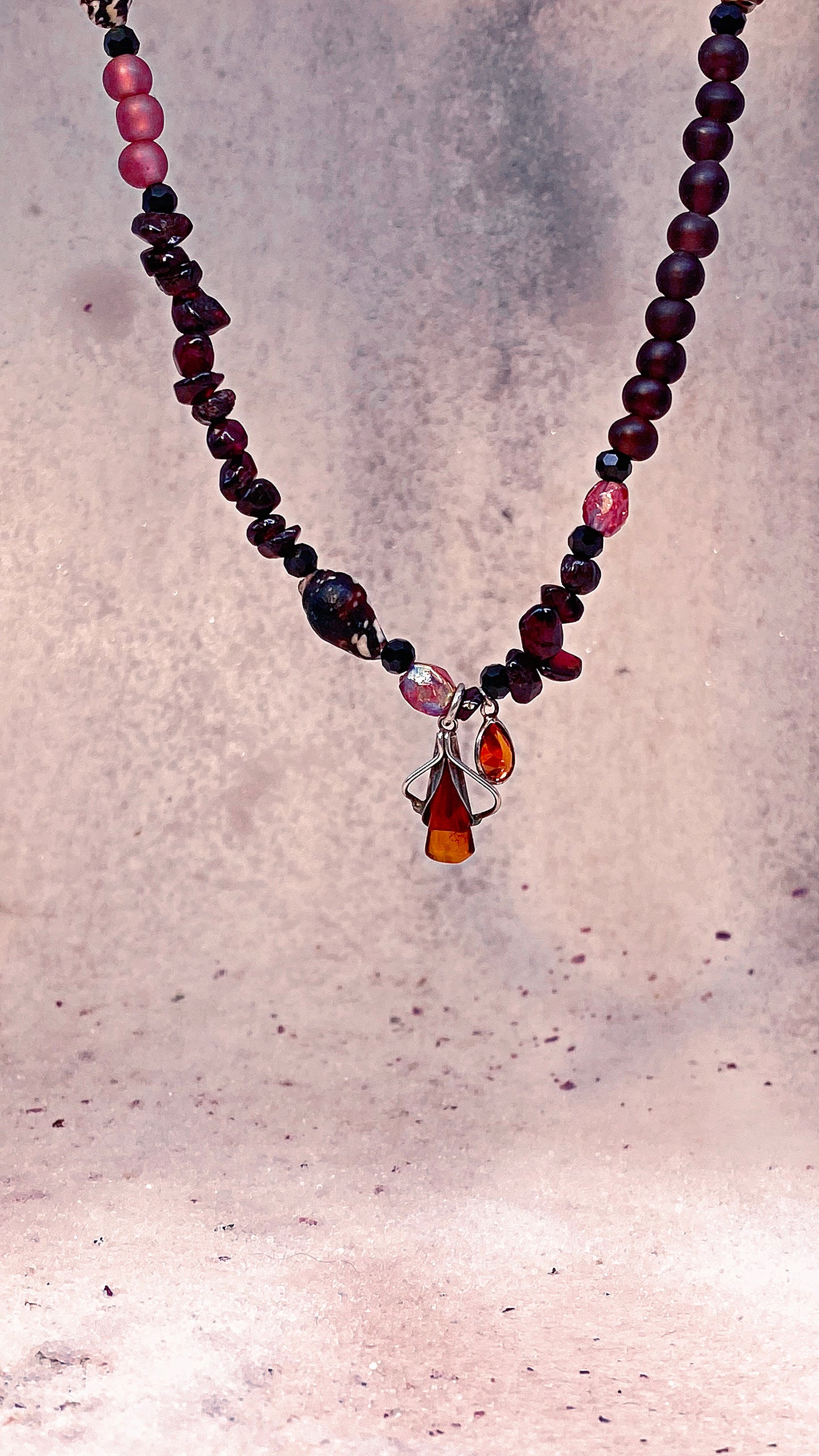 amber droplet and mini fire droplet on textured garnet, seashell, glass