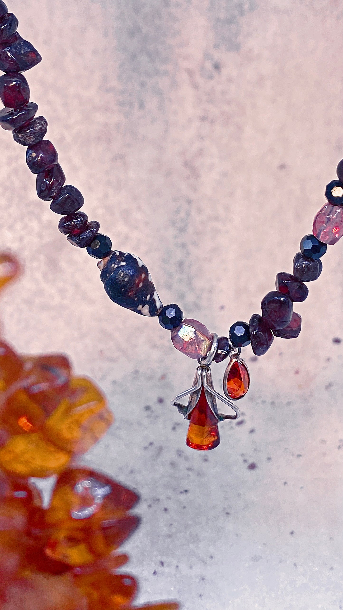 amber droplet and mini fire droplet on textured garnet, seashell, glass