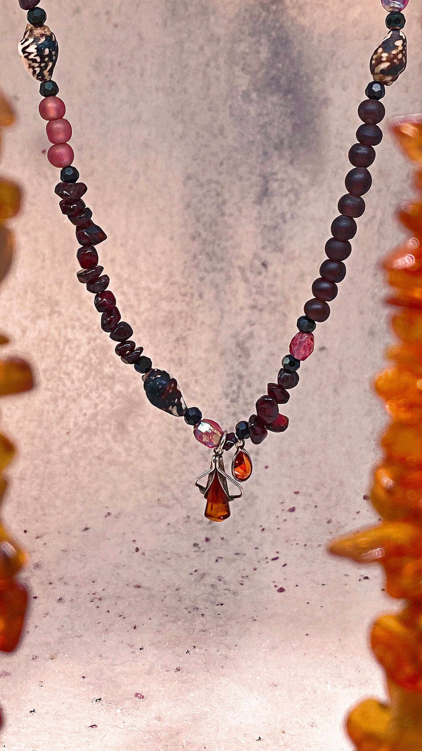 amber droplet and mini fire droplet on textured garnet, seashell, glass