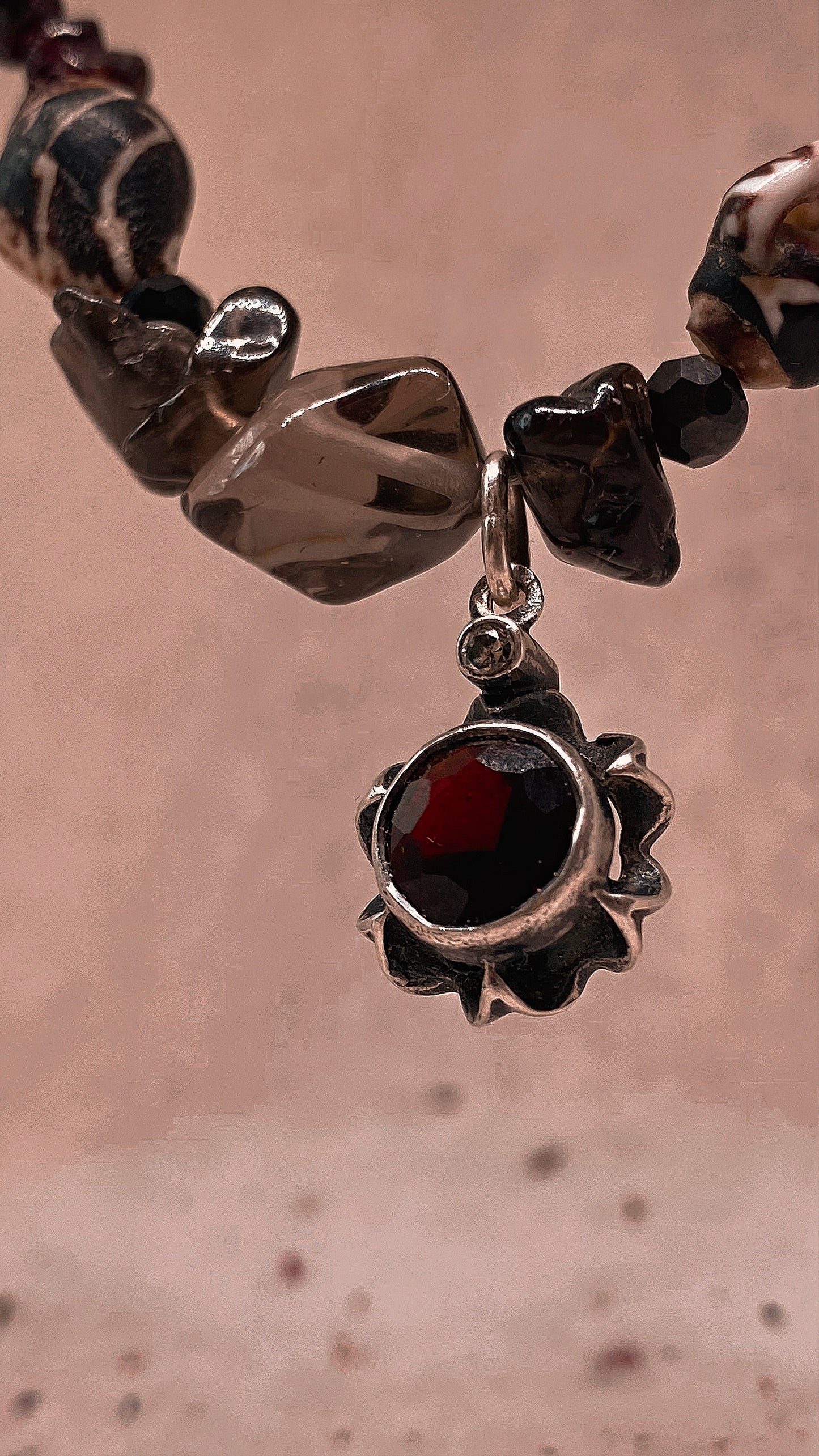 faceted garnet flower on textured garnet, seashell, glass