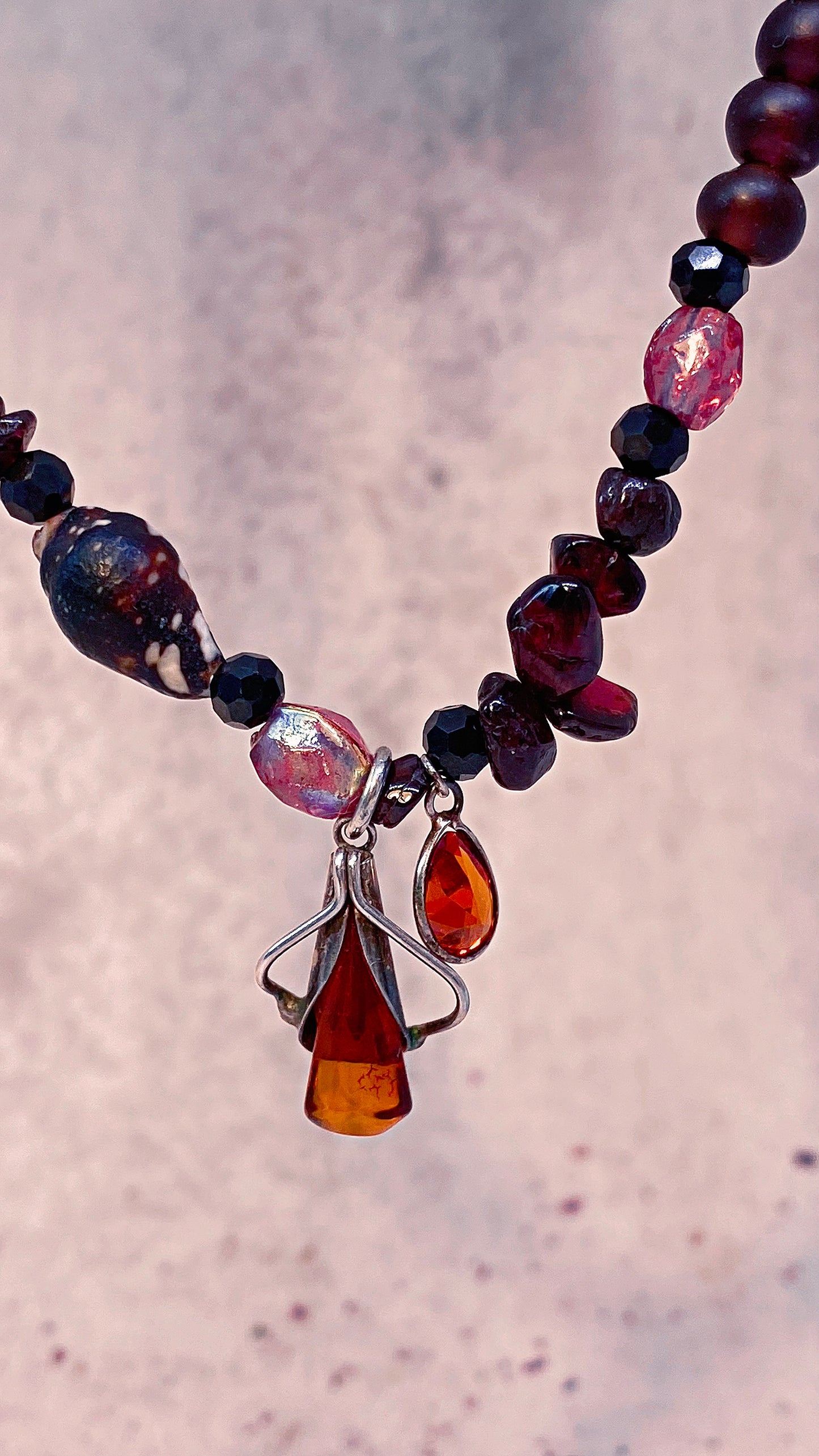 amber droplet and mini fire droplet on textured garnet, seashell, glass