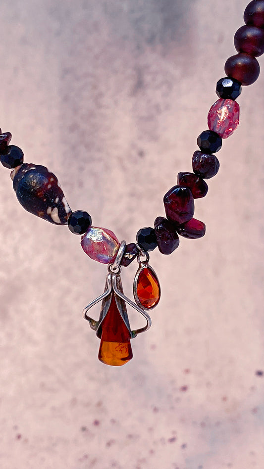 amber droplet and mini fire droplet on textured garnet, seashell, glass