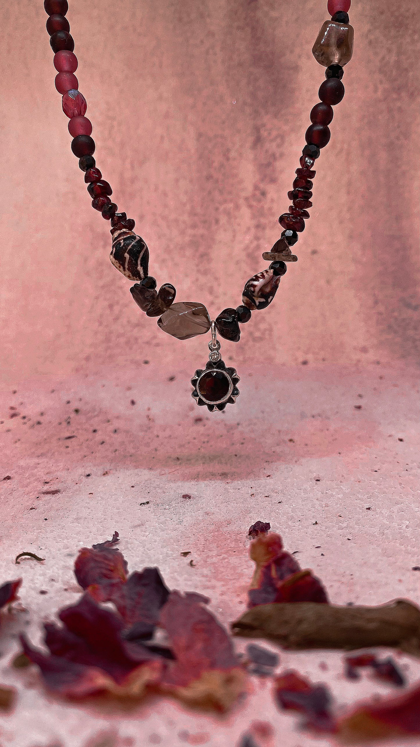 faceted garnet flower on textured garnet, seashell, glass