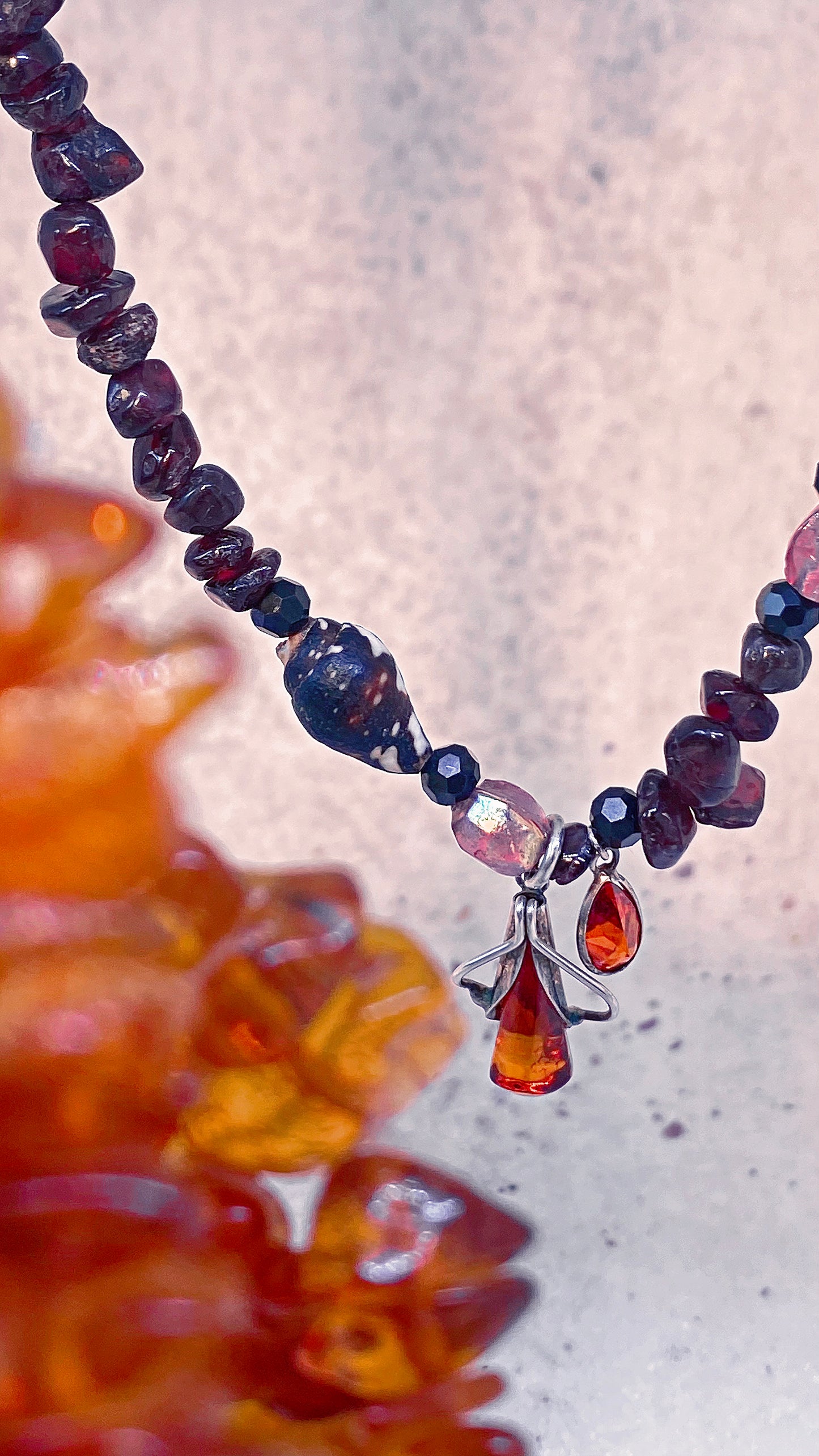 amber droplet and mini fire droplet on textured garnet, seashell, glass
