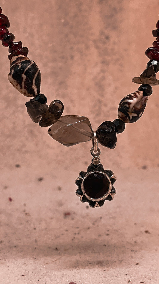 faceted garnet flower on textured garnet, seashell, glass